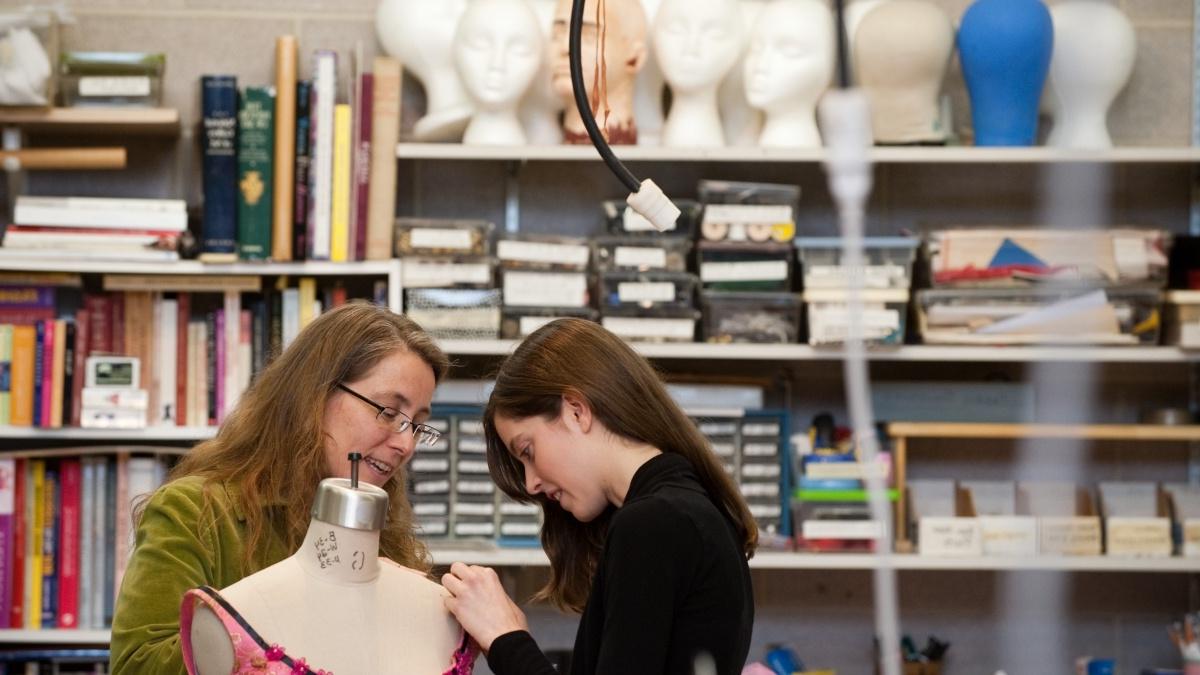 Two women working on a costume.